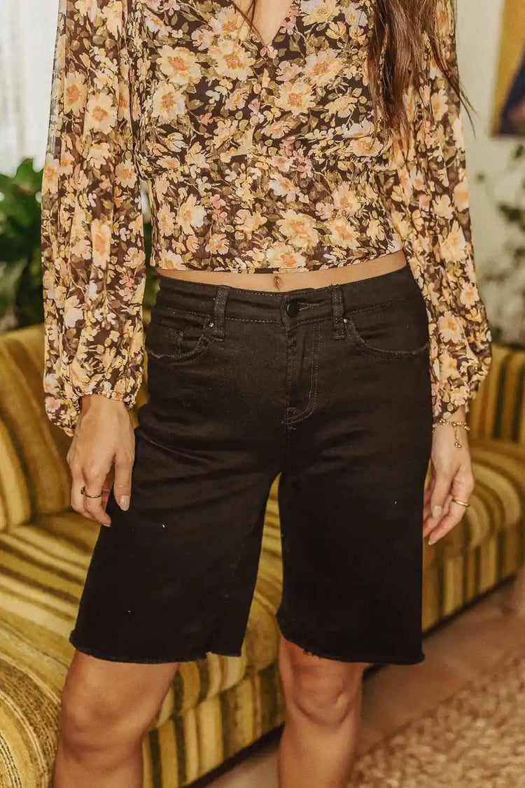 Bermuda shorts in black paired with a floral top 