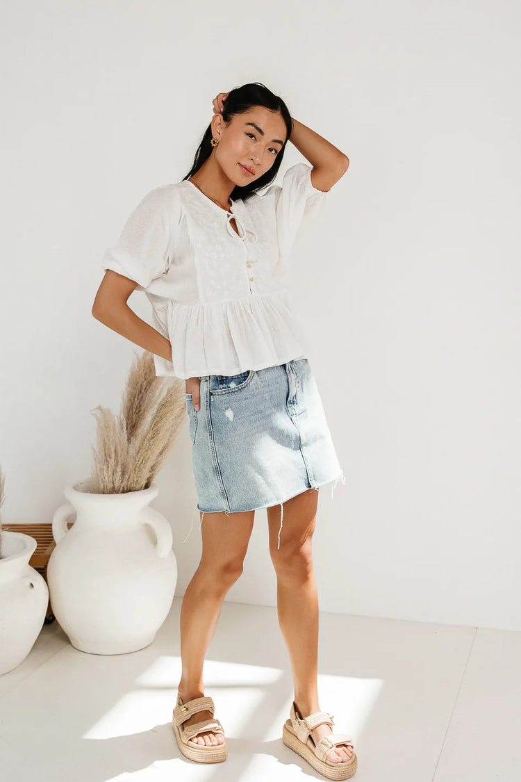 Top paired with a denim mini skirt 