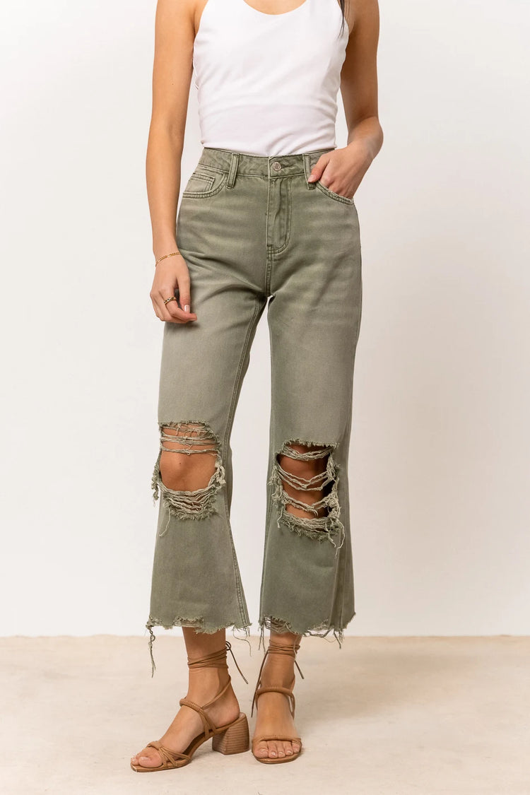 olive distressed denim with raw hem and holes in knees