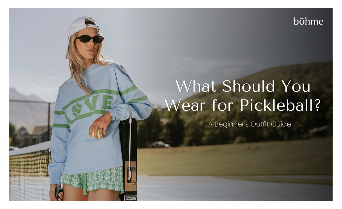 Woman in blue graphic sweatshirt and shorts on a pickleball court