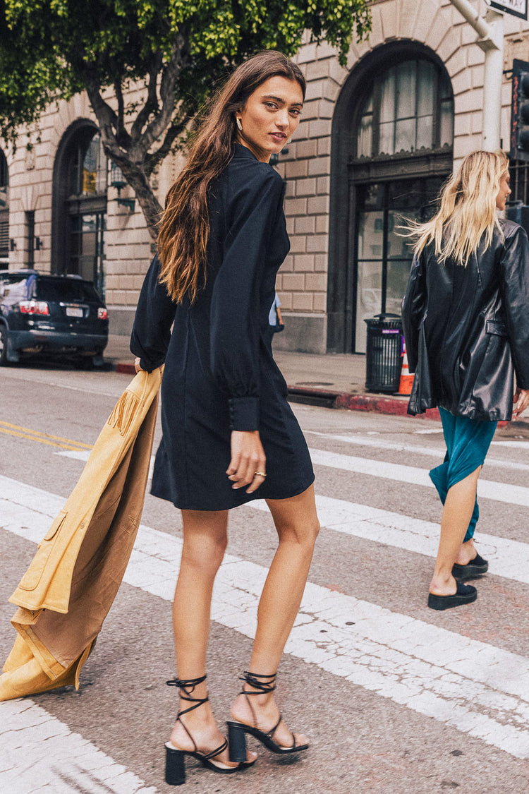 a women walking wearing a black dress