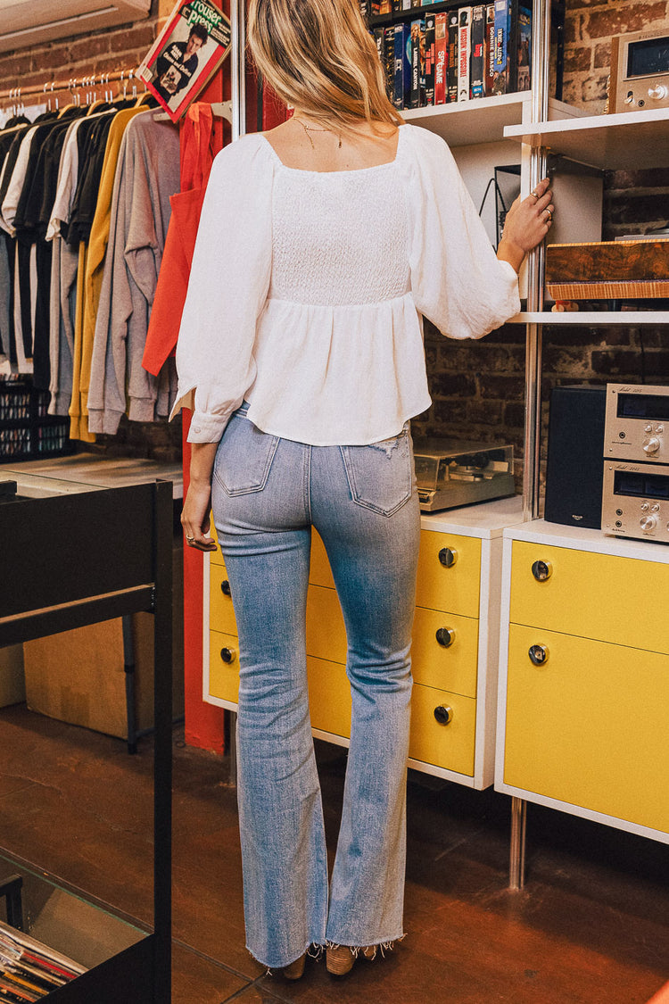 back view of flare jeans and a white long sleeve top