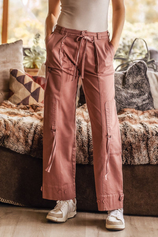Pink Cargo pants with strings falling from the knees