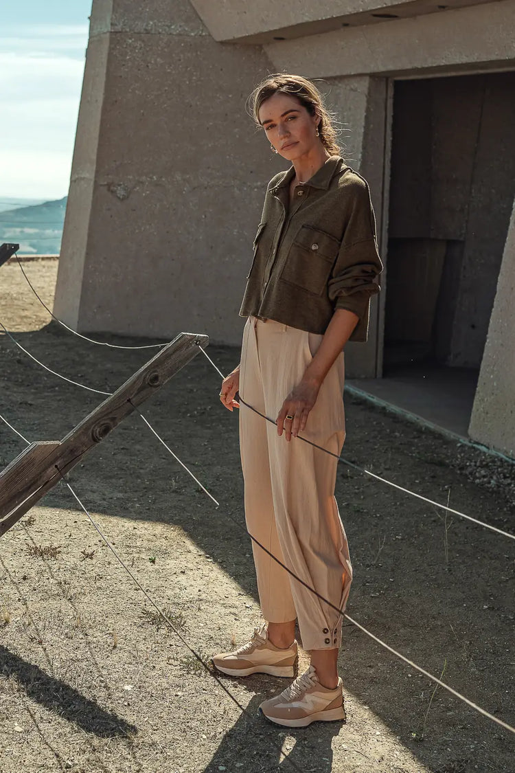 Woven pants in beige paired with an olive top 
