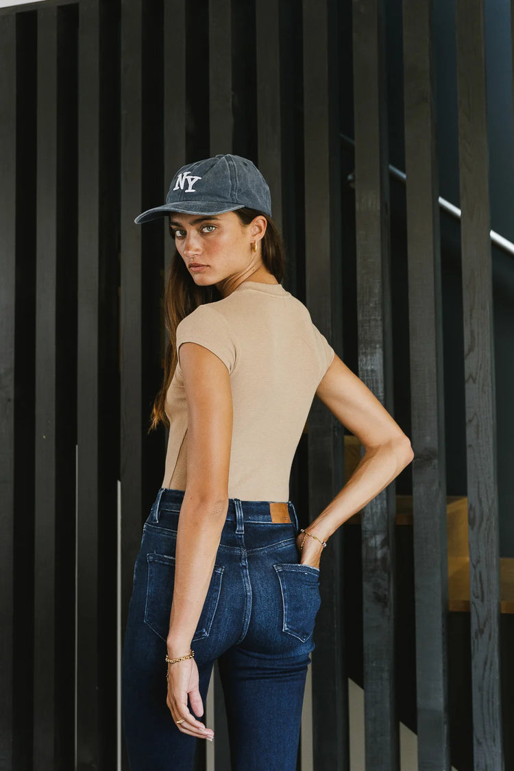 tan bodysuit paired with blue baseball cap