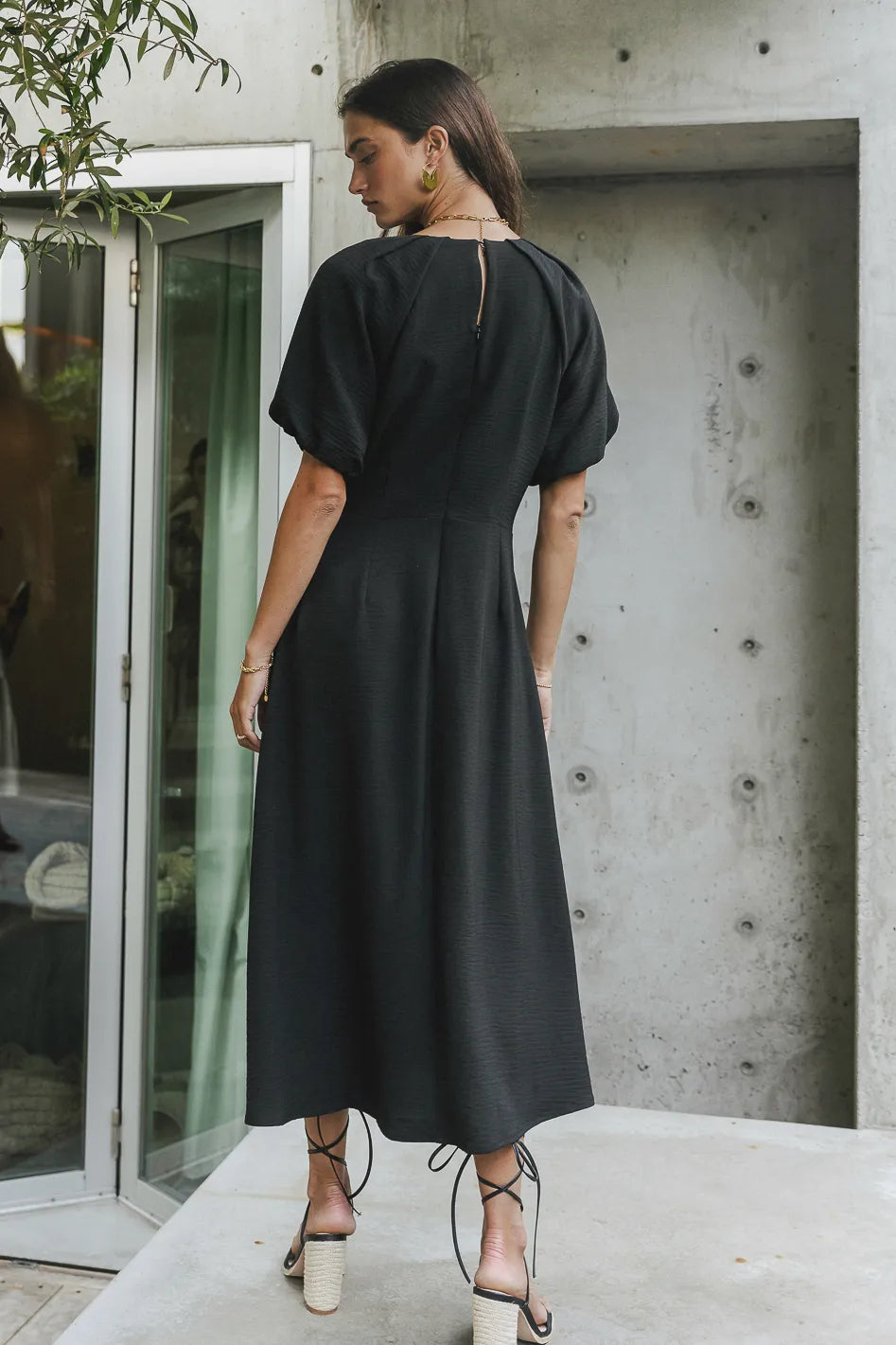 backside of black midi dress with button closure