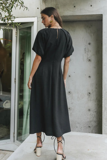 backside of black midi dress with button closure