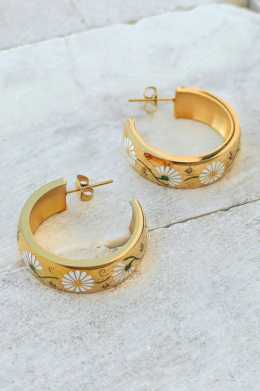 med size gold hoop earrings with white floral details 