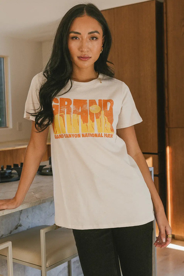 cream t- shirt showcasing graphic centered on the chest area 