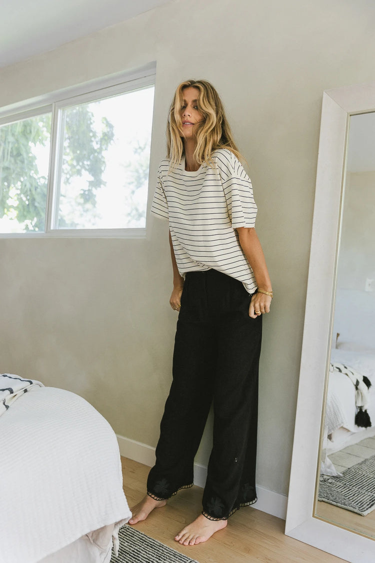 Wide leg embroidered pants in black paired with a striped top 