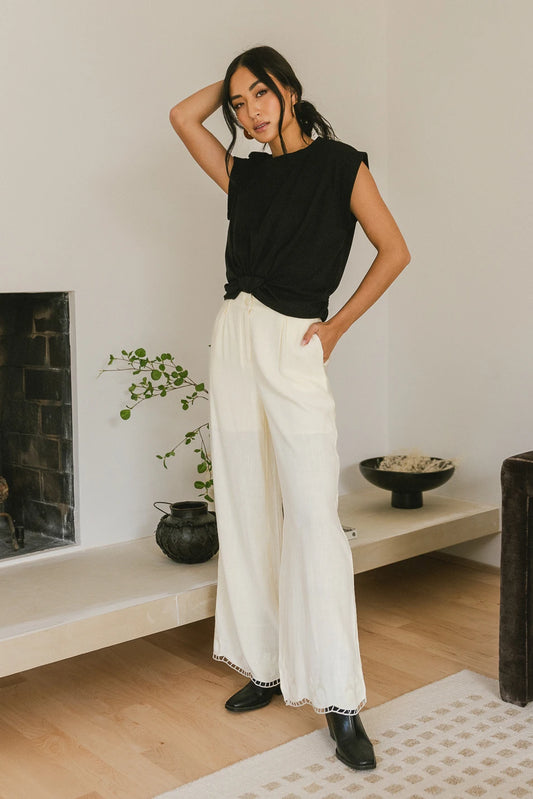Embroidered hem pants in cream paired with a black top 
