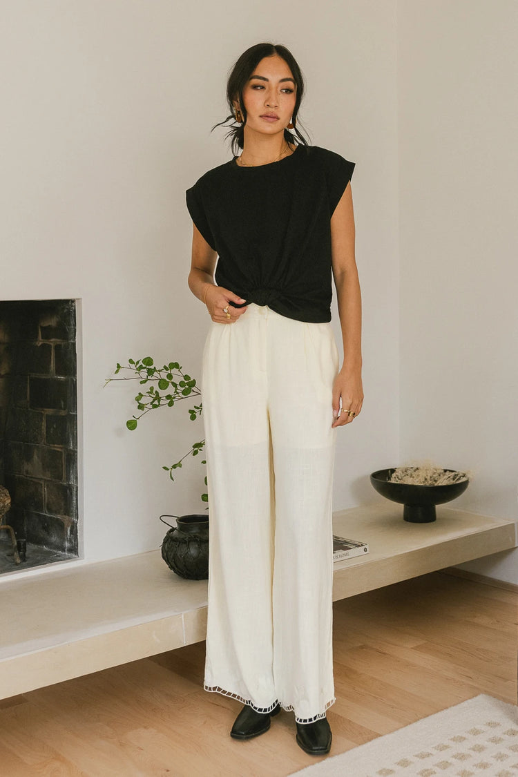 Top in black paired with a wide leg pants in cream 
