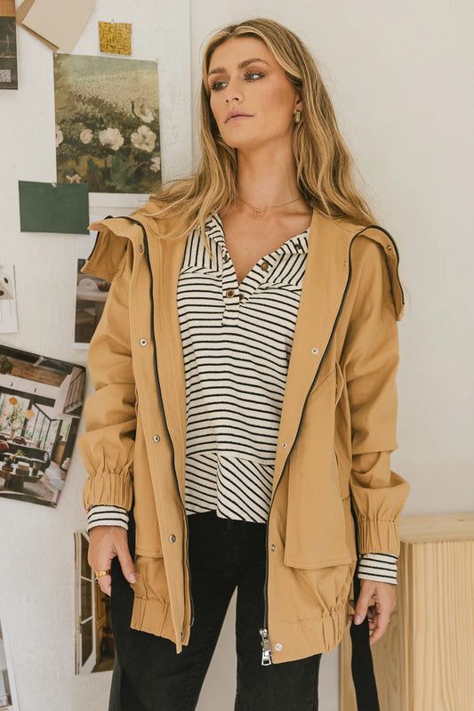Hooded jacket in camel paired with a striped top 