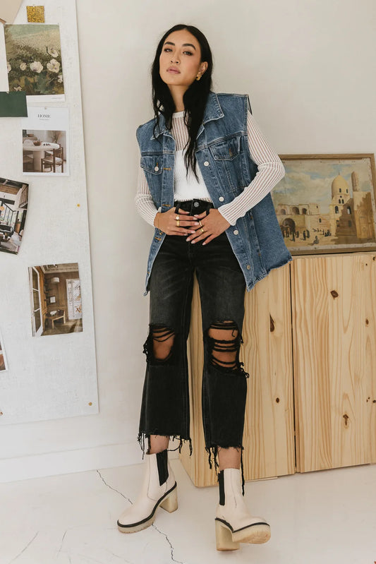 Distressed denim in black paired with a denim vest 