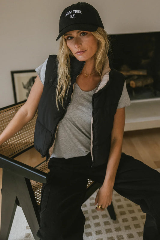 Knit top in grey paired with a black vest 