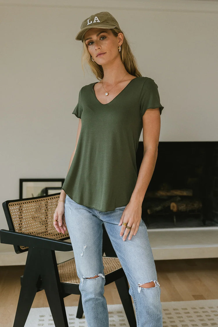 Knit top in olive paired with distressed denim pant  