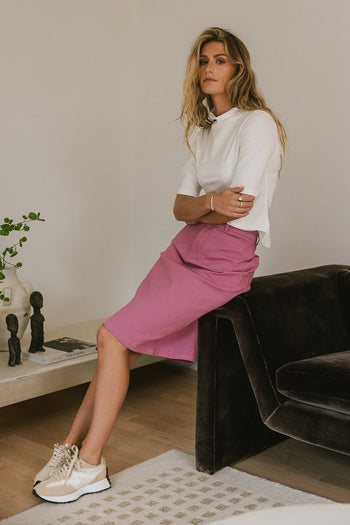 Short sleeves mock neck paired with a midi pink skirt 