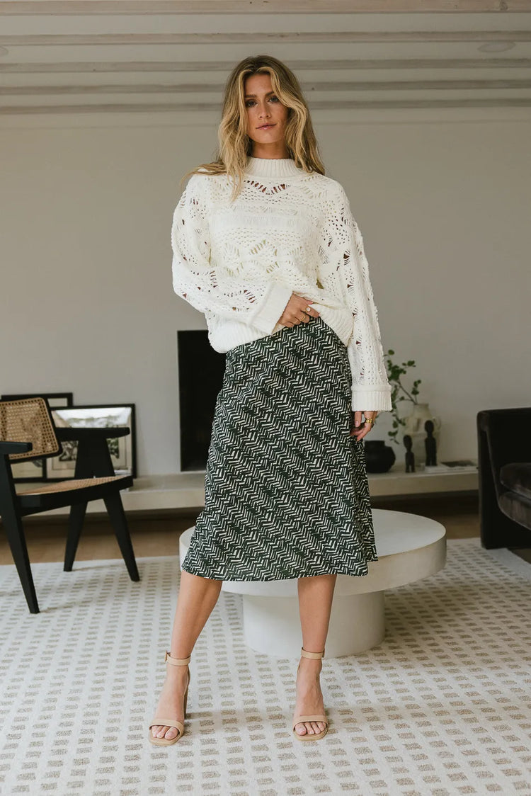 Woven printed skirt in green paired with a cream sweater 