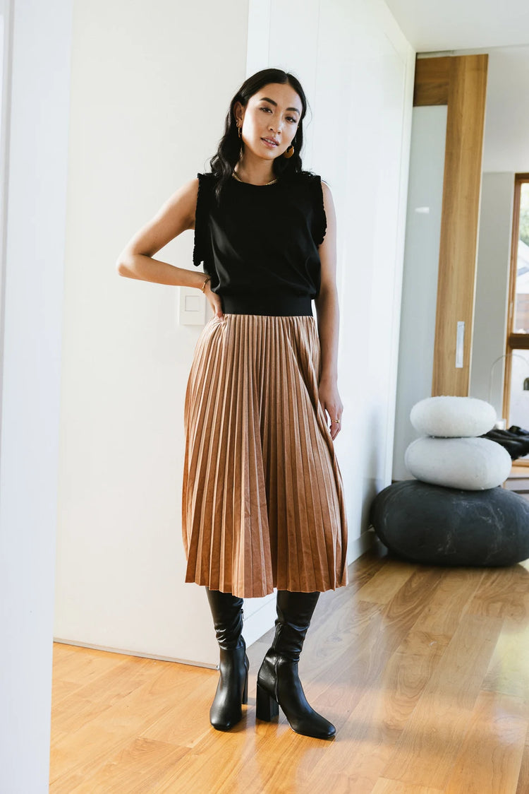 Tank top in black paired with a pleated skirt 