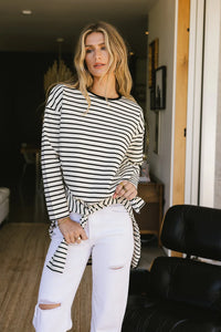 Striped top in black and white paired with white jeans 