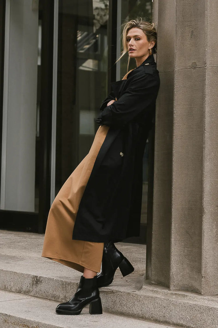 Maxi dress in camel paired with a black trench coat 