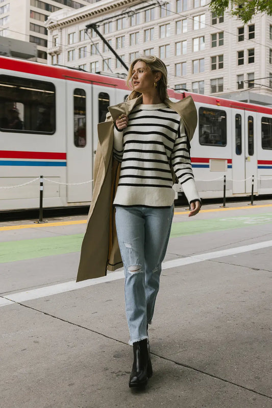 Striped sweater paired with a light distressed denim 