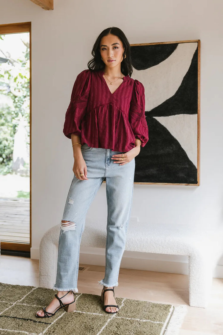 Blouse in burgundy paired with a distressed denim jean 
