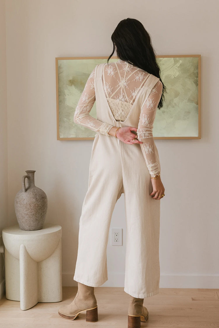 Jumpsuit in cream paired with a long sleeves sheer top 