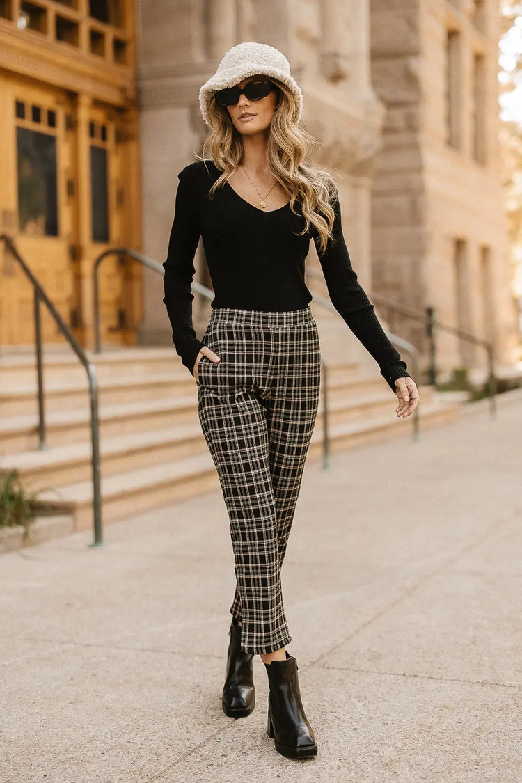High rise plaid pants paired with a sweater in black 