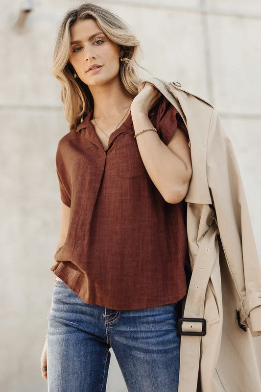 Top in burgundy paired with a trench coat 