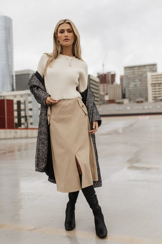 Corduroy skirt paired with a sweater in ivory 