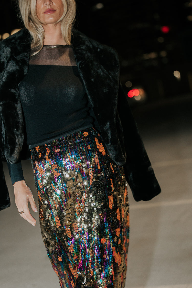Faux fur jacket paired with a satin multi color skirt 