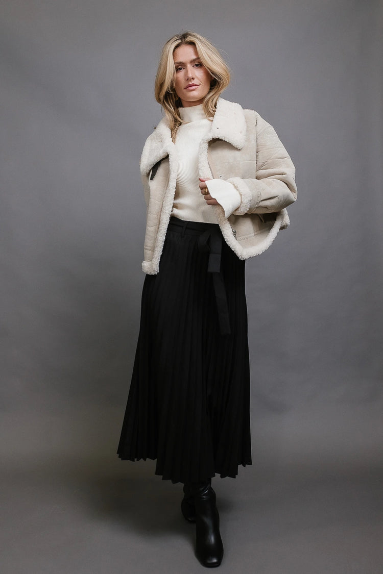 Pleated skirt in black paired with a jacket 