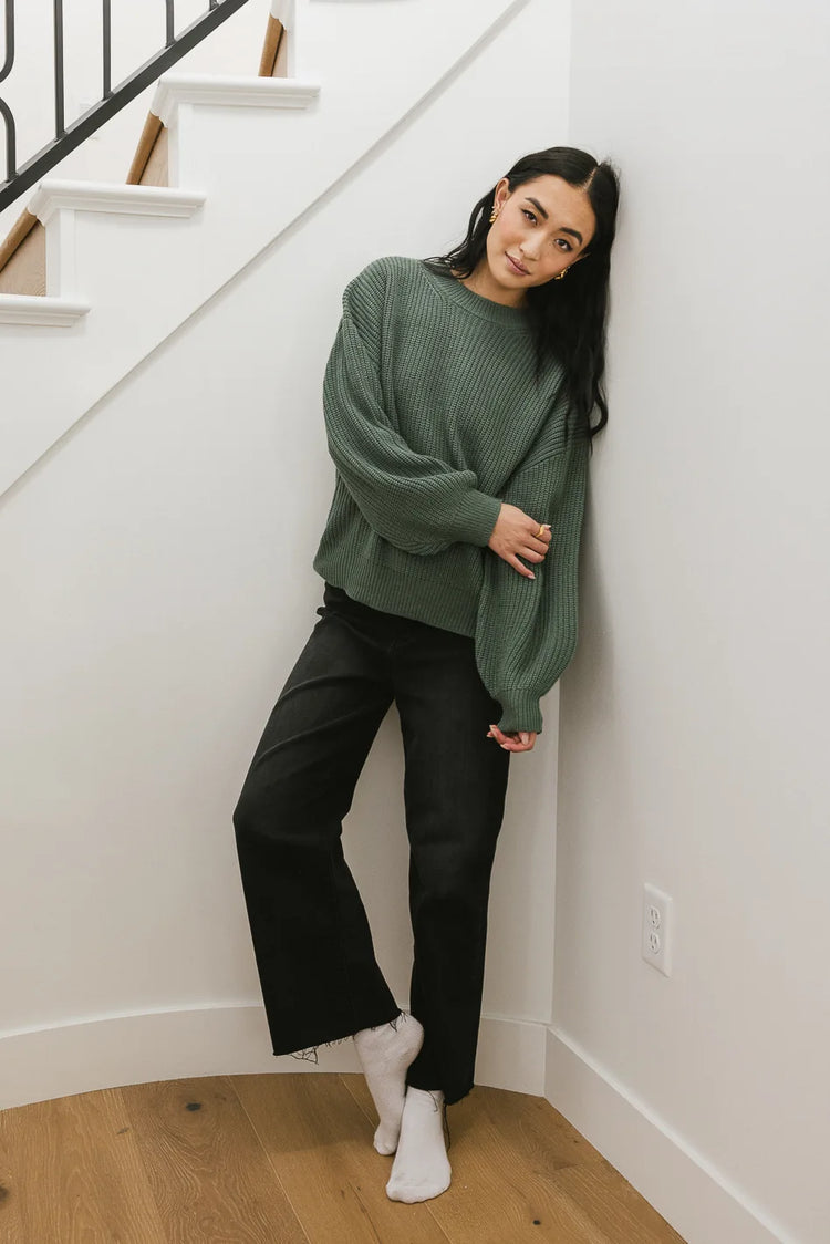Sweater in green paired with a black denim 