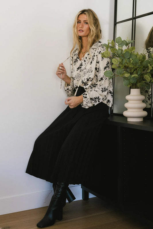 Blouse with flowers print paired with a black skirt 
