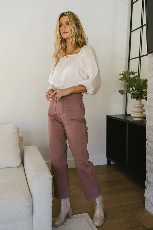 Pants in mauve paired with a cream blouse 