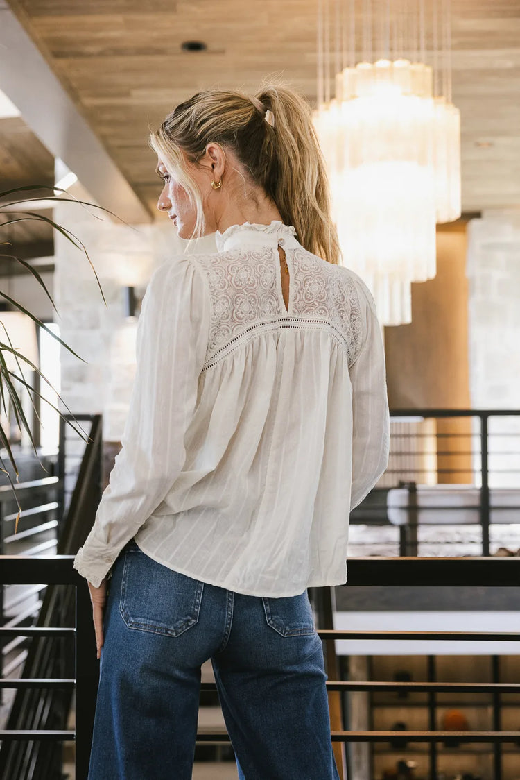 Top in cream paired with blue jeans 