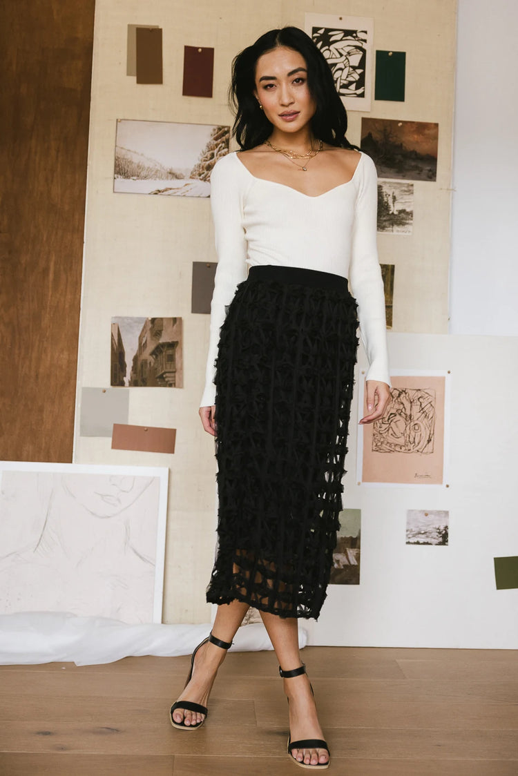 Open cage skirt in black paired with a cream long sleeves top 