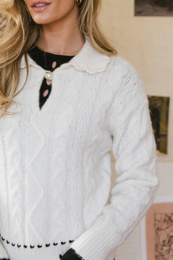 V Cut out with a pearl button sweater in cream 
