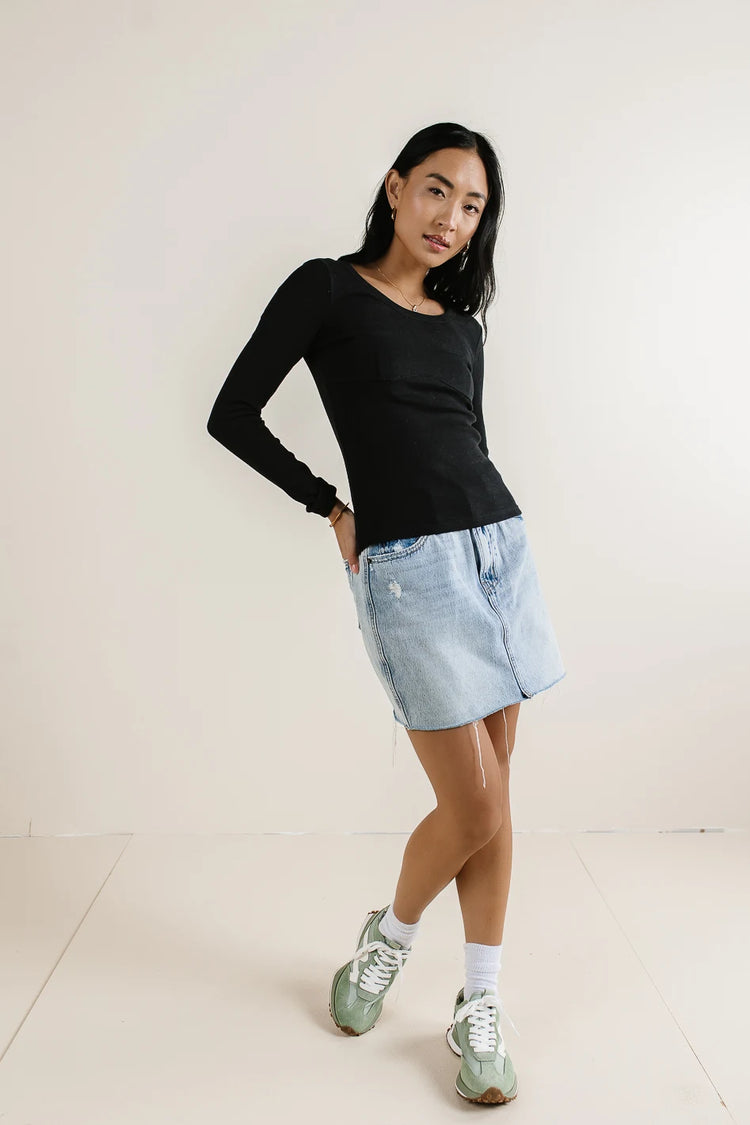 Top in black paired with a denim skirt 