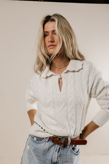 collared knit sweater with black stitching and pearl button