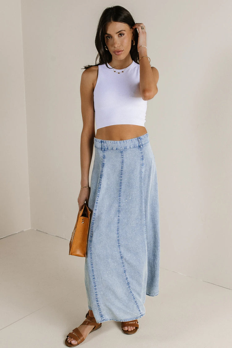 Denim skirt paired with a white tank top 