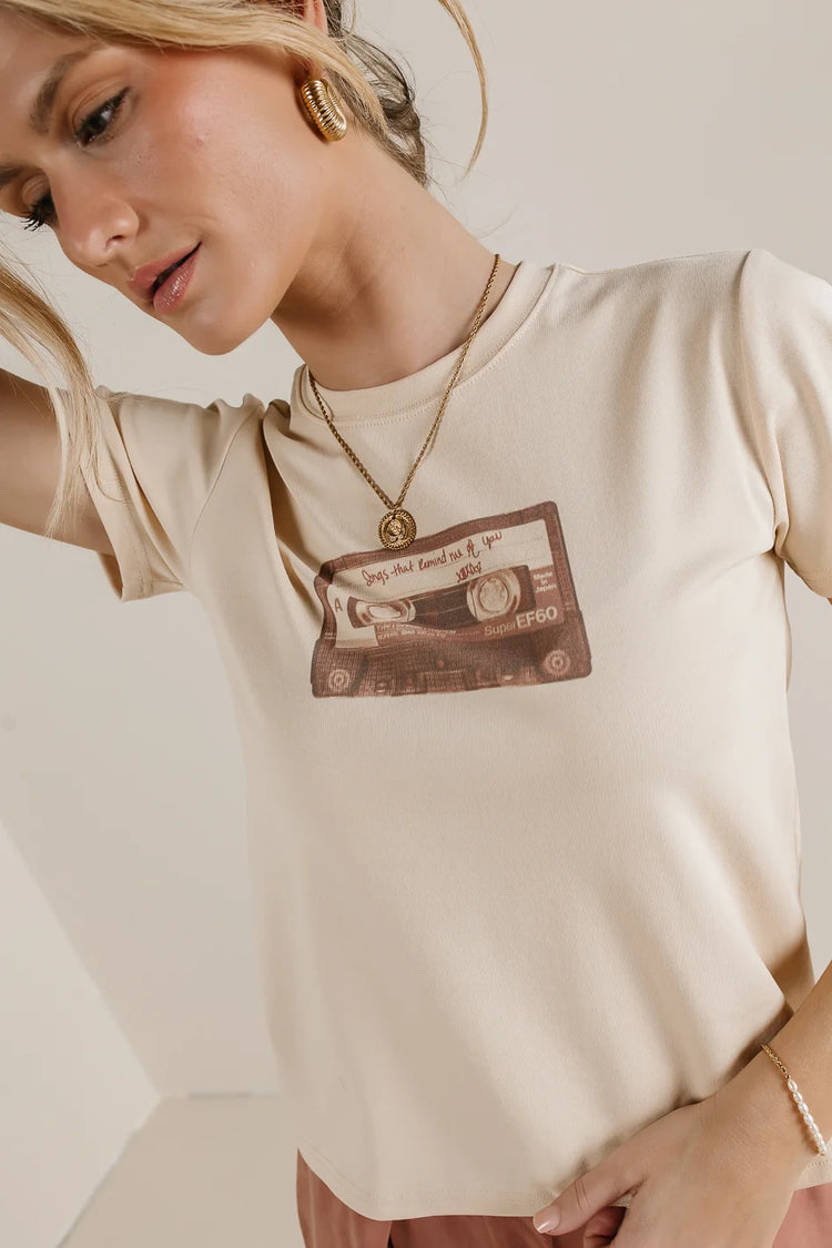 Round neck top in cream with a radio front design 