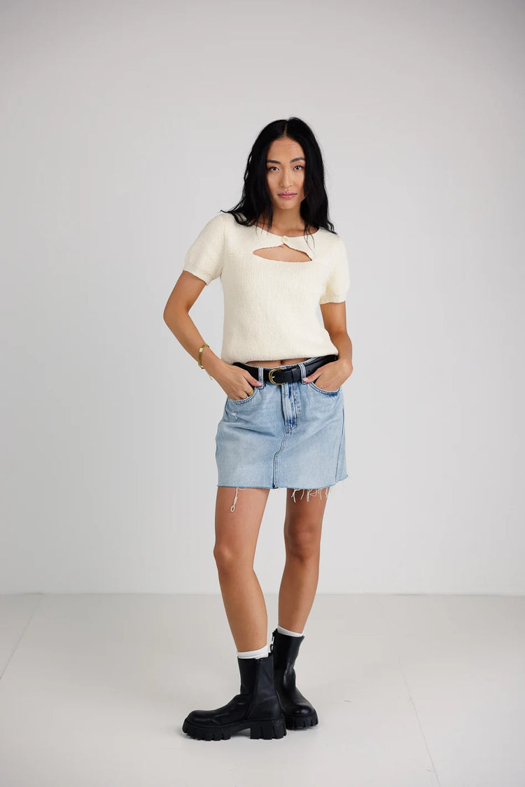 Top in cream paired with a mini denim skirt 
