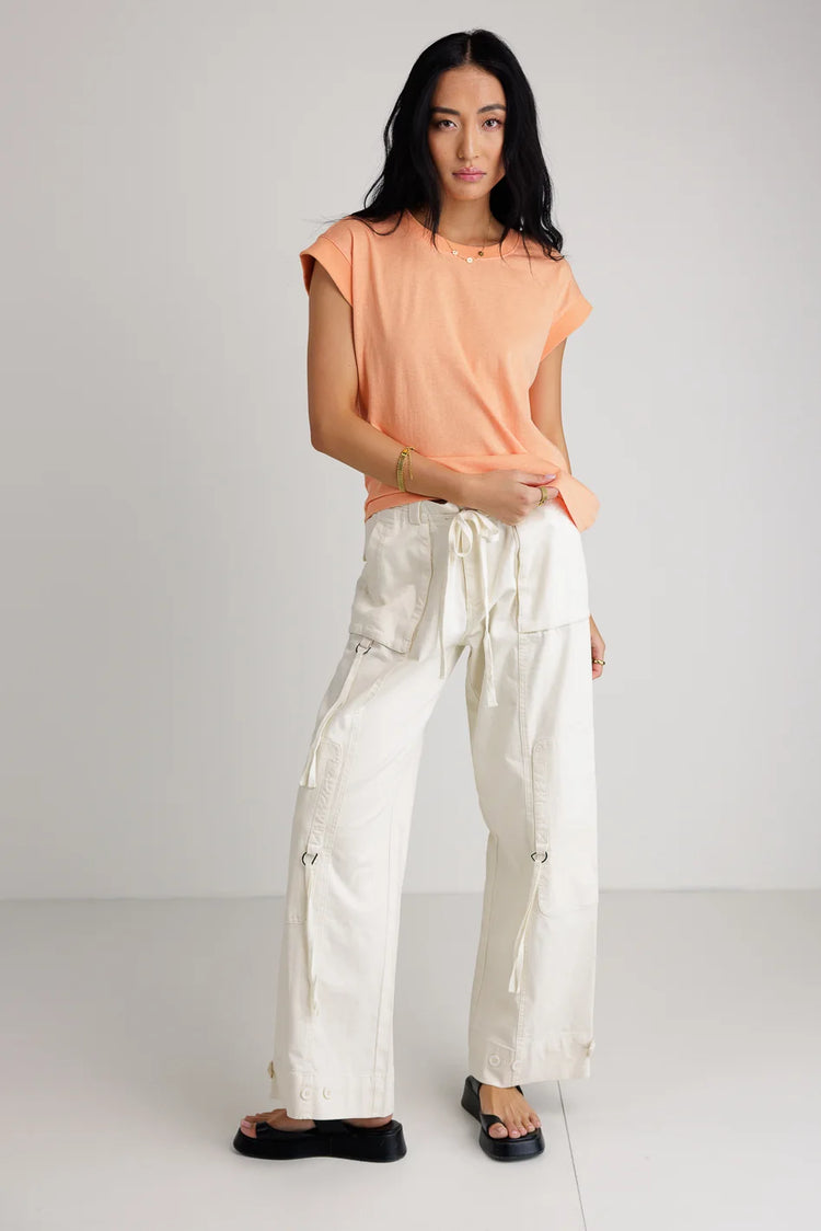 Top in peach paired with a cream cargo pants 