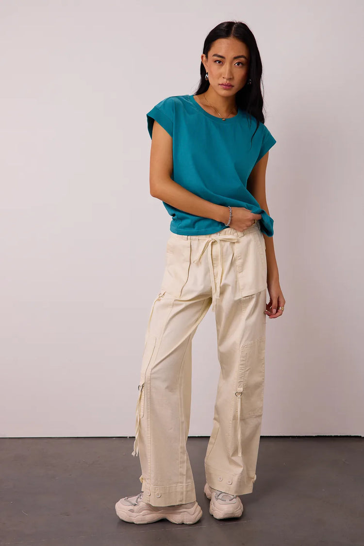 Top in teal paired with a moto pants in cream 