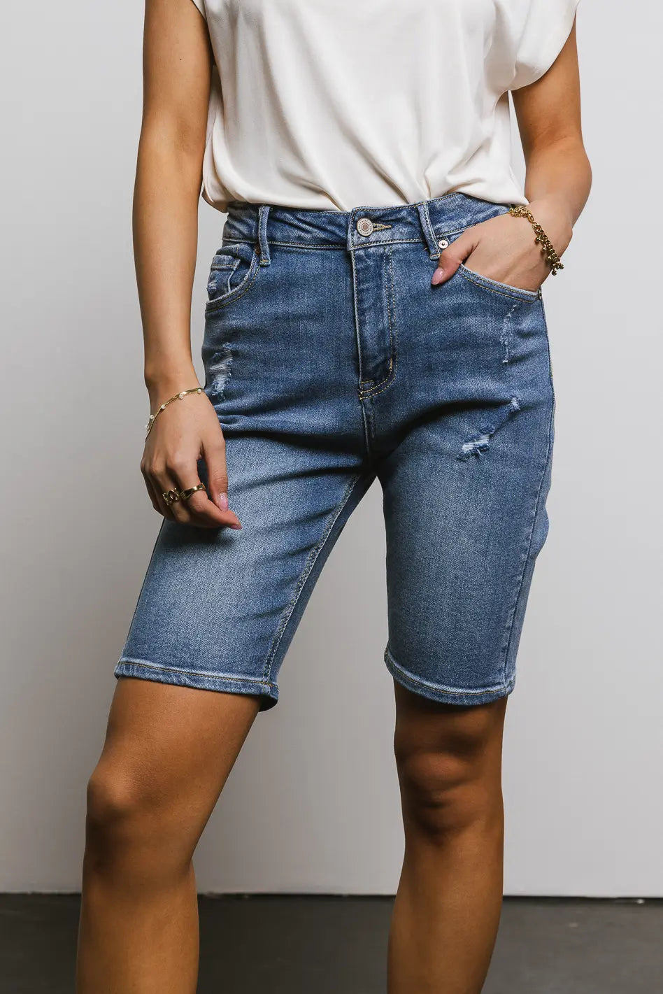 Distressed bermuda short in medium wash 