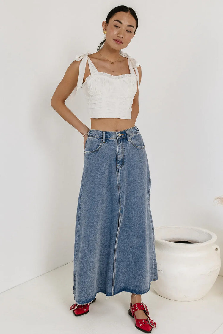 top in white paired with a denim skirt 