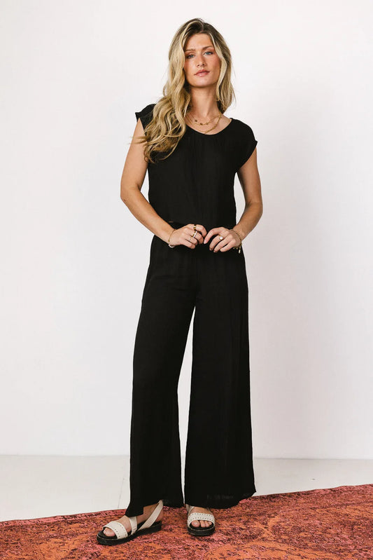 Top in black paired with a wide leg pants 