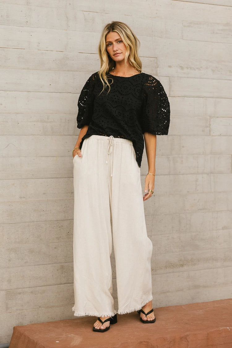 Top in black paired with a wide leg pants 